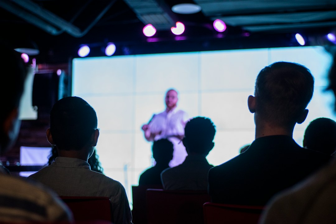 Audience watching a speaker presentation on a large screen